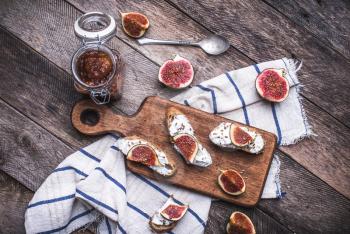 Tasty Bruschetta with jam and figs on napkin in rustic style. Breakfast, lunch food photo