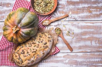White bread with pumpkin seeds on wooden table. Rustic style