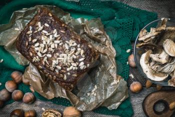 Closeup of bread with seeds, nuts and mushrooms in rustic style
