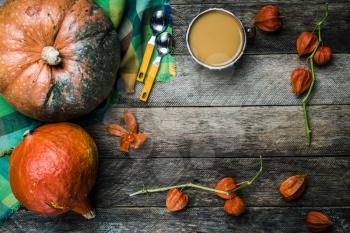 Rustic style pumpkins vegetable soup and ground cherry on wood. Autumn Season food photo