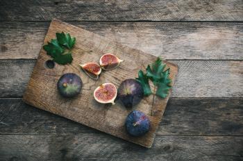 Ripe Figs on chopping board and wood. Autumn season food photo
