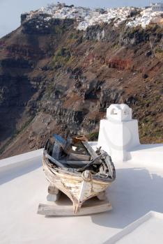 Royalty Free Photo of an Old Boat on a Rooftop in Santorini, Greece