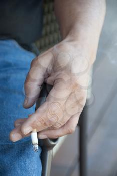 Royalty Free Photo of a Man's Hand Holding a Cigarette