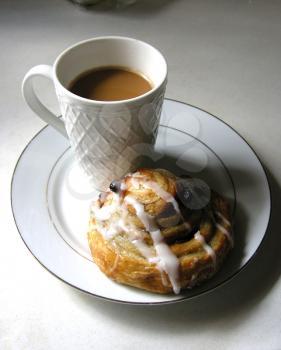 Royalty Free Photo of a Cup of Coffee and a Cinnamon Bun