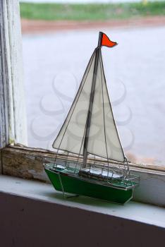 Royalty Free Photo of a Miniature Sailboat in a Window
