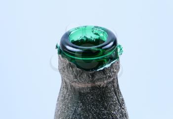 neck of green bottle on blue background