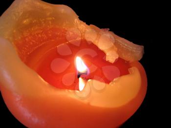 orange burning candle on a black background