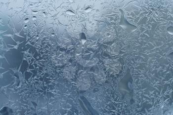 window glass with frost and water drops