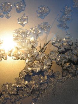 frosty natural pattern and sun on winter windowpane