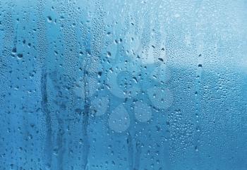 Blue natural background with water drops on glass