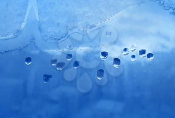 Texture of window glass with water drops, ice pattern and sunlight