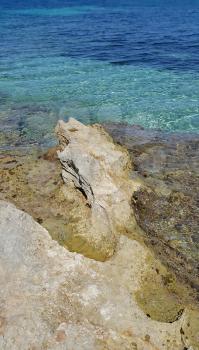 Bright turquoise sea water and coastal rocks, nature background