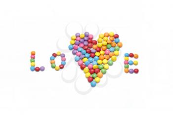 Word ''Love'' and abstract heart from bright colorful candy isolated on white background