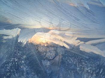 Ice pattern and sunlight on winterr glass