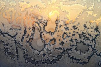 Beautiful ice pattern and bright sunlight close-up on winter window glass