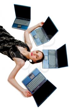 Royalty Free Photo of a Woman Lying on the Floor Surrounded by Laptops
