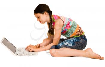 Royalty Free Photo of a Young girl Sitting on the Floor Using a Laptop