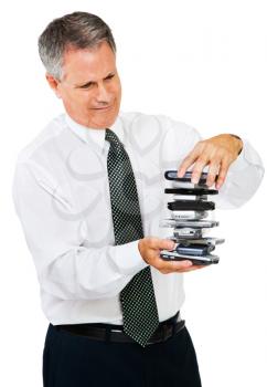 Royalty Free Photo of a Businessman Holding a Stack of Mobile Phones