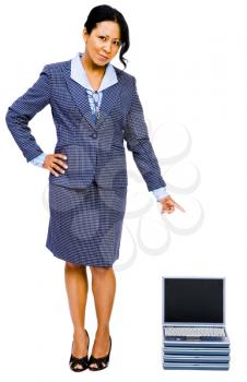 Happy businesswoman pointing towards laptops and posing isolated over white