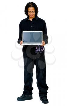 Young man showing a laptop and smiling isolated over white