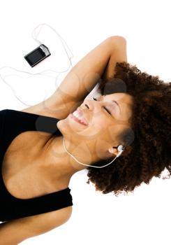 Gorgeous woman listening to music on a MP3 player isolated over white