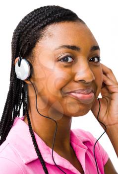 Happy teenage girl listening to music on headphones isolated over white