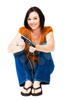 Portrait of a woman listening to music on an media player isolated over white