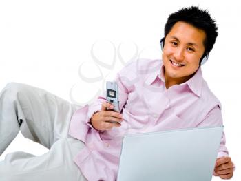 Chinese man using a laptop and a mobile isolated over white
