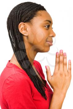 African teenage girl praying and smiling isolated over white