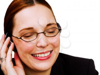 Close-up of a businesswoman listening to music on a headphones isolated over white