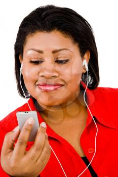 Woman listening to music on MP3 player and smiling isolated over white