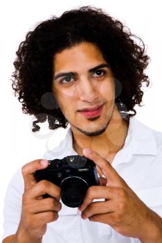 Fashion model photographing with a camera and smiling isolated over white