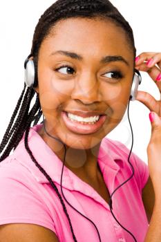 Close-up of a teenage girl listening to music on headphones isolated over white