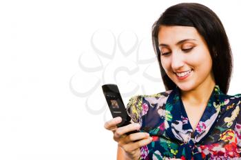 Confident woman text messaging on a mobile phone isolated over white