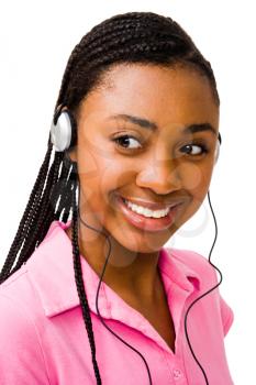 Teenage girl listening to music on headphones and smiling isolated over white