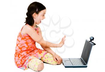 Happy girl using a laptop and posing isolated over white
