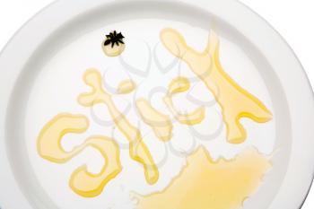 Text written with honey on a plate isolated over white