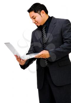 Young businessman using a laptop and smiling isolated over white