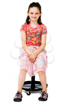 Portrait of a girl sitting on a stool and grinning isolated over white