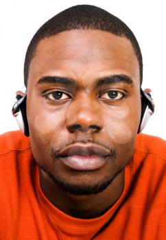 Young man wearing headphones and listening to music isolated over white