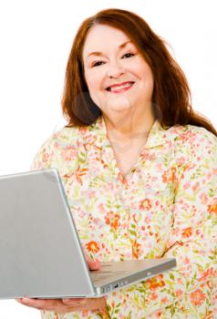 Smiling woman using a laptop isolated over white