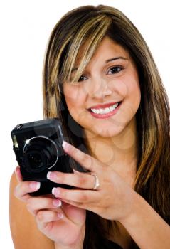 Young woman photographing with a camera and smiling isolated over white