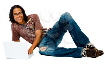 Smiling man using a laptop and posing isolated over white