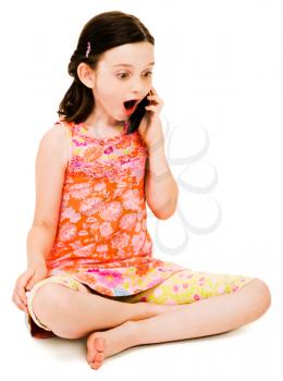 Surprised girl talking on a mobile phone isolated over white