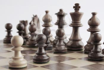 White pawn facing black chess pieces on a chess board
