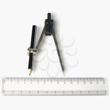 Close-up of a pencil with a drawing compass and a ruler