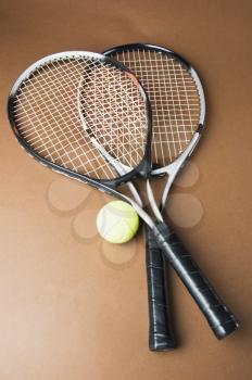 Close-up of two tennis rackets with a tennis ball