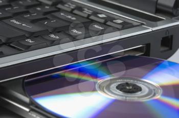 Close-up of a laptop ejecting a CD