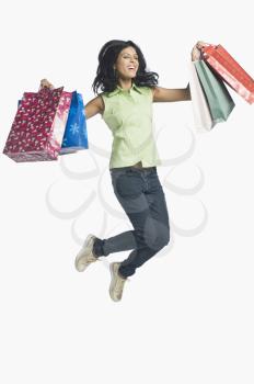 Woman carrying shopping bags and jumping