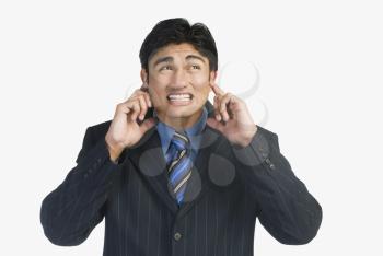 Businessman with his fingers in ears